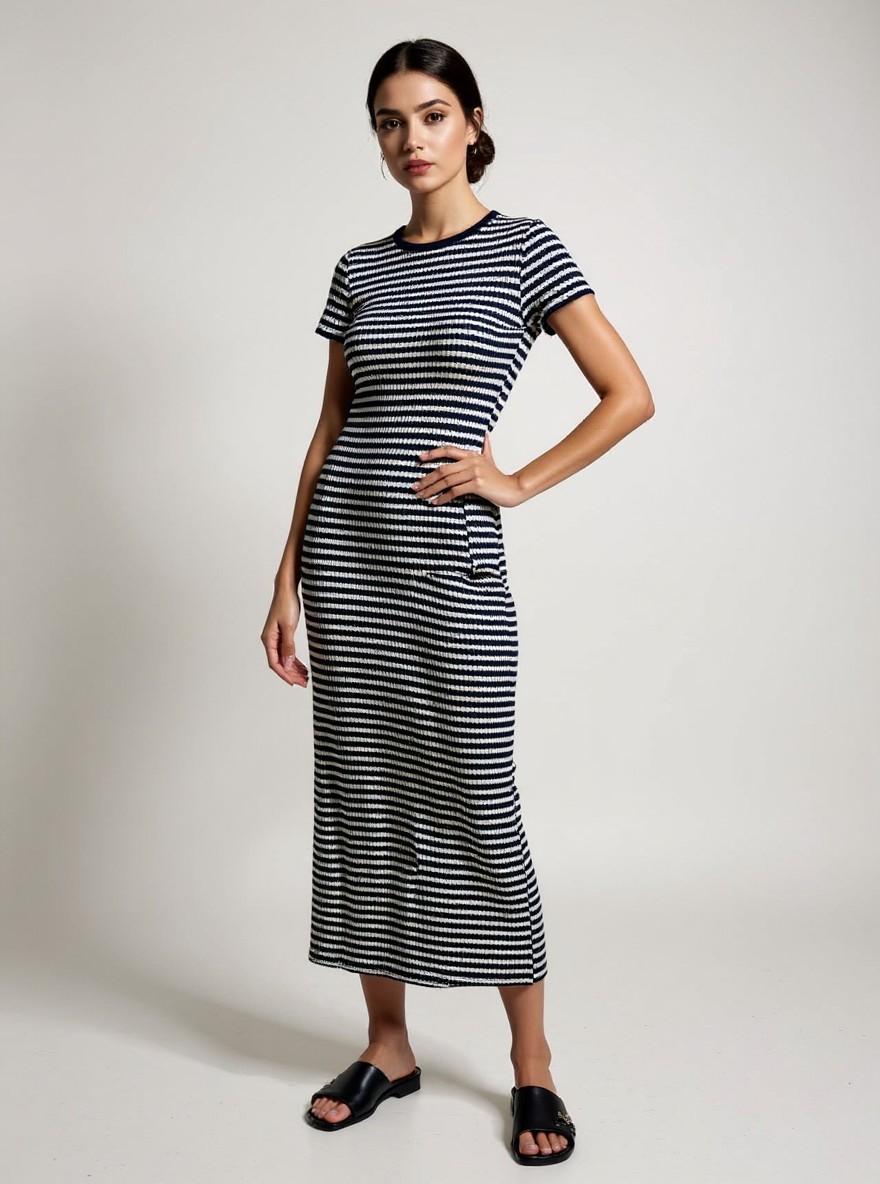 The Stripe Maxi in Navy, three-quarter view, standing with hand on hip