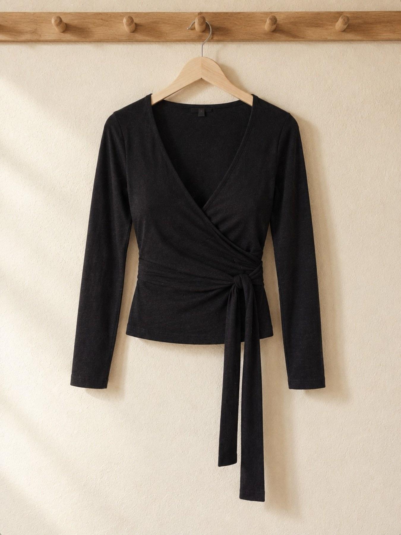 The Wrap Top in Black, on the hanger