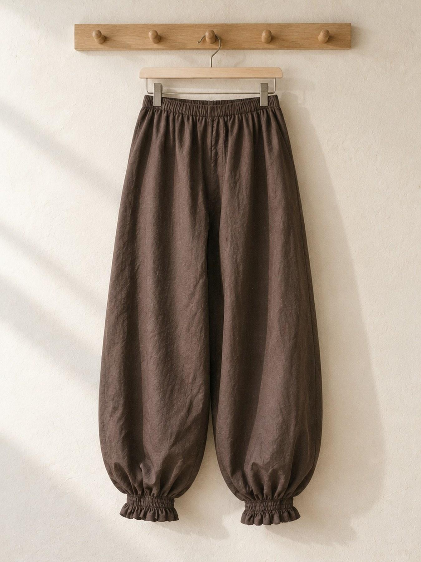 The Parachute Trouser in Brown, on the hanger