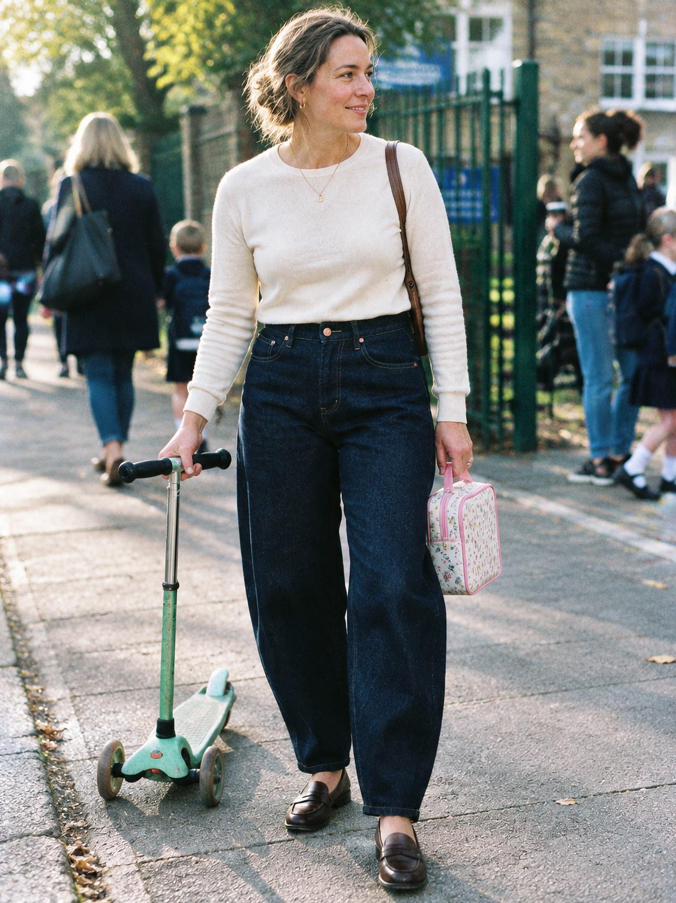 The Barrel Jean in Indigo, full length, walking outdoors with a scooter